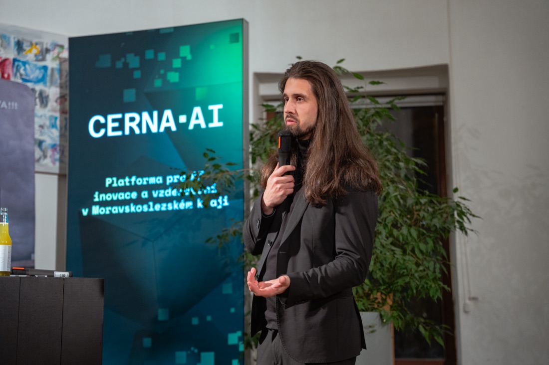 Dalibor Mráz na pódiu ČERNÁ.AI s mikrofonem